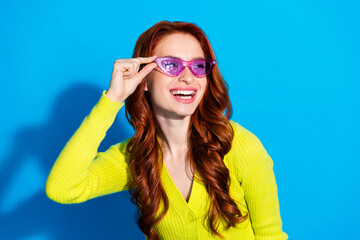Photo portrait of lovely young lady sunglass look empty space dressed stylish yellow garment isolated on blue color background