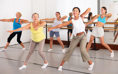 Group of dancers exercising modern dance movements in large ball room