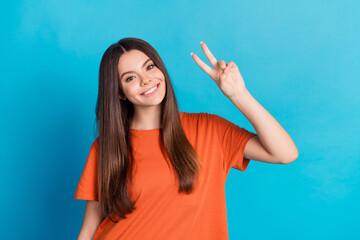 Fototapeta premium Photo portrait of attractive teen woman show v-sign dressed stylish orange clothes isolated on blue color background