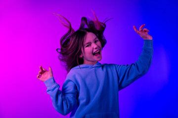 Photo of carefree attractive little lady dressed hoodie dancing empty space isolated neon pink color background