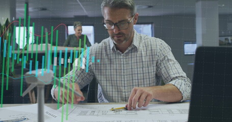 Image of graph processing data over caucasian male architect working on blueprints