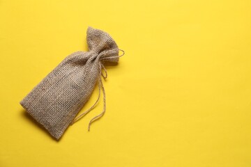 One burlap sack on yellow background, top view. Space for text