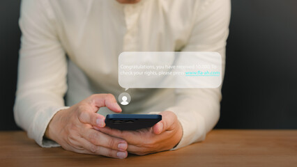 Man holding a smartphone and viewing messages on his mobile phone. Fake Text message SMS scam or...