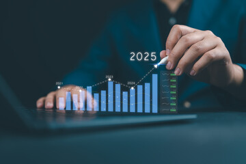Businessman analyzes the graph of trend market growth in 2025 and plans business growth and profit...