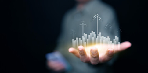 Finance, business, investment, or economy growing graph concept. A man with rising arrows and graphs in his hand. The chart and arrows represening the growth and increase.