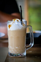Butter beer in a beer mug with straw.