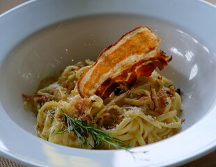Carbonara with crispy bacon on top.