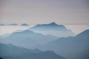Obraz premium Serene alpine landscape at dawn in Gailtal Alpen, Carinthia, Austria, Europe. Silhouette of majestic hazy mountain ridge of Dobratsch peak. Peaceful tranquil atmosphere in Austrian Alps. Wanderlust