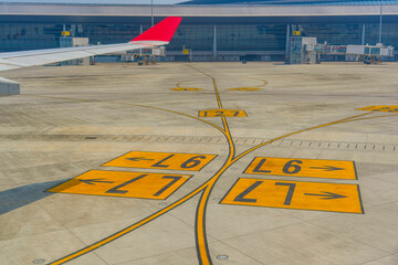 Markings with indicators, lines and numbers on taxiways for aircraft movement with a view of the...