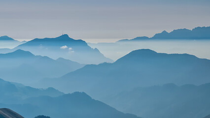Fototapeta premium Serene alpine landscape at dawn in Gailtal Alpen, Carinthia, Austria, Europe. Silhouette of majestic hazy mountain ridges of Julian Alps. Peaceful tranquil atmosphere in Austrian Alps. Wanderlust