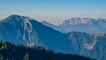 Serene alpine landscape seen from Latschur in Gailtal Alpen, Carinthia, Austria, Europe. Silhouette of majestic hazy mountain ridges of Carnic Alps. Peaceful tranquil atmosphere. Wanderlust. Freedom