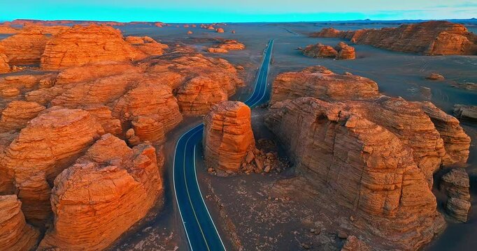 Aerial view of spectacular Yadan landform and road landscape at sunset. The famous Dahaidao uninhabited area natural landscape in Xinjiang, China.