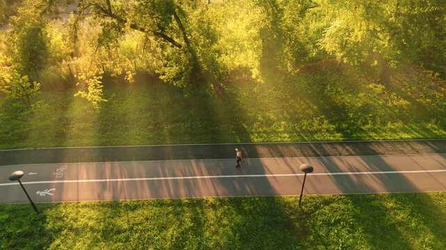 Morning jogger enjoying sunlight along a peaceful park pathway