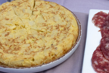 plate with Spanish potato omelet next Spanish pork chorizo sausage slices