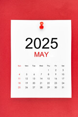 May 2025 calendar page with push pin on red background.