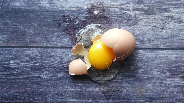 Fresh broken egg on a wooden table 