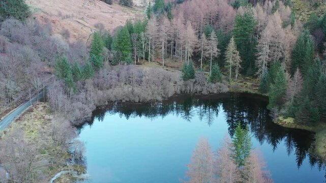 Slowly rising aerial footage over Torren Lochan looking towards the snow capped three sisters mountains