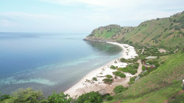 A peaceful coastline in dili timor leste with green hills and calm waters, aerial view