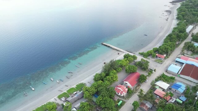 Coastline with colorful buildings, beach, and calm waters in dili, timor-leste, aerial view