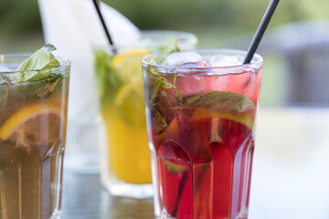 Three drinks on a table, one of which is a pink drink