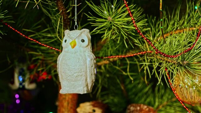 Silver owl. Christmas tree, toy decorations. New Year and Merry Christmas. Smooth camera movement on the slider. Video postcard. Live christmas tree with garlands and toys