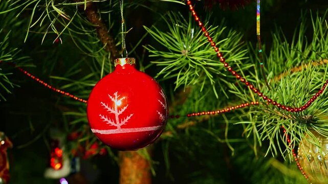 Red ball. Christmas tree, toy decorations. New Year and Merry Christmas. Smooth camera movement on the slider. Video postcard. Live christmas tree with garlands and toys