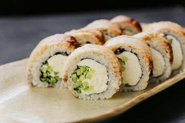 Grilled eel sushi rolls with cream cheese and cucumber on plate, perfect for Japanese cuisine lovers