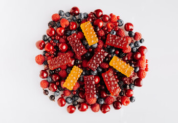 Colorful natural berry marmalade on fresh mixed fruits and berries, healthy sweet indulgence