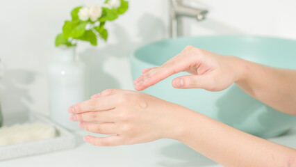Macro shot at two model hands with a drop of cosmetic gel on the back of one hand. The creative...
