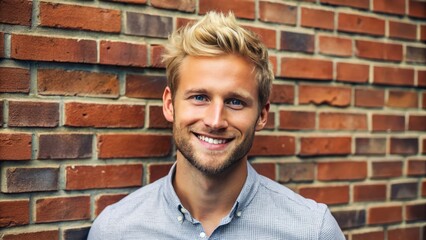 Obraz premium The man with a bright smile poses confidently in front of a worn brick wall, his short blonde