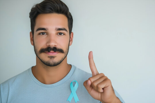 Man with stylish mustache wearing a blue ribbon pin pointing to a Menth health awareness poster isolated on a white background 