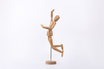 Wooden human figure jumping in sign of joy isolated on white background. Copy Space. Concept of joy and happiness