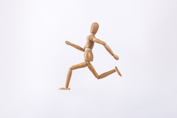 Wooden dummy representing a person running isolated on white background. Copy space. Concept of activity and sport