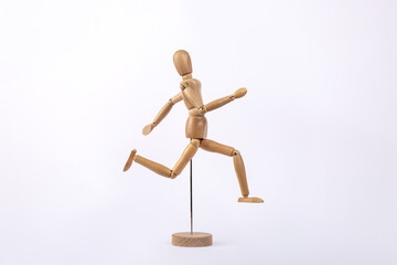 Wooden human figure representing a person running, isolated on white background. Copy space. Concept of activity and sport