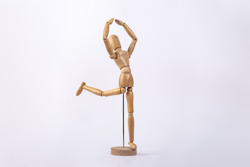 Wooden dummy representing a person dancing, isolated on white background. Copy space. Concept of dance