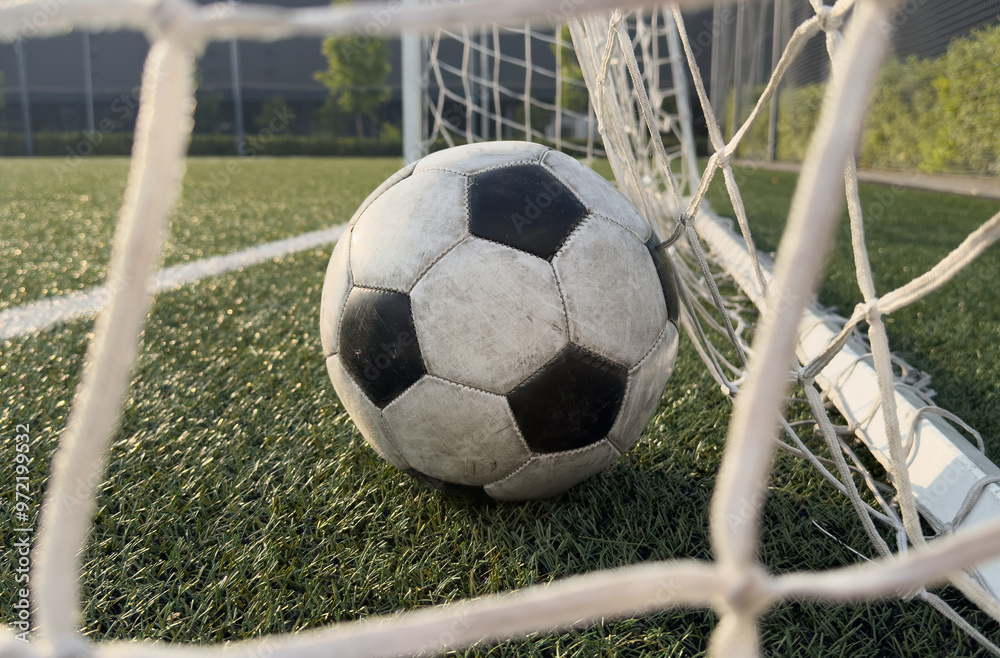 Wall mural Soccer ball in goal on blue background