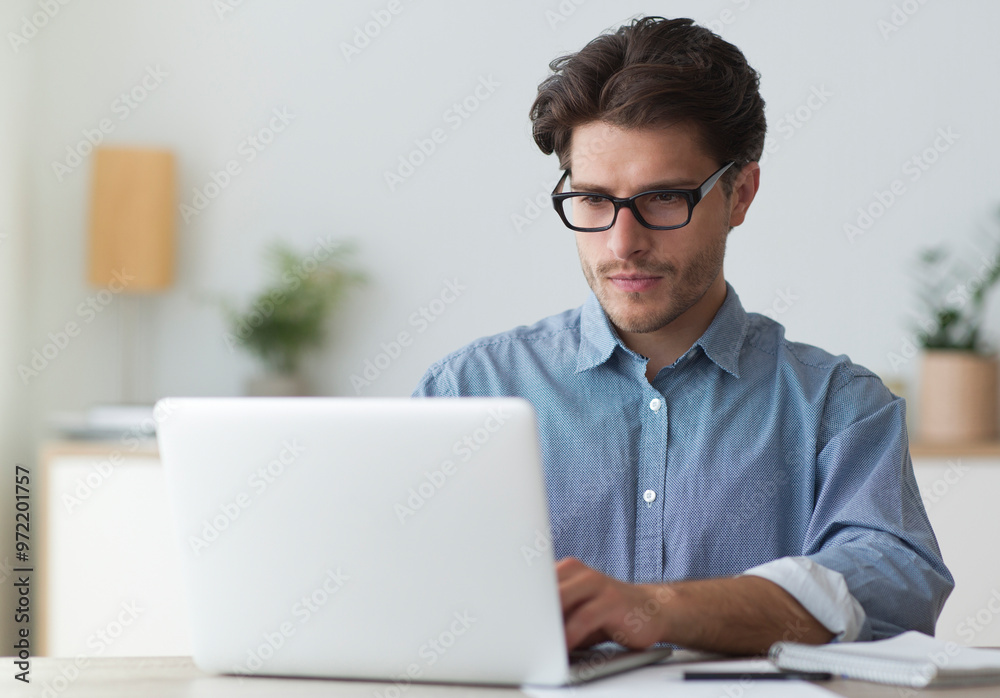 Poster serious businessman working at laptop computer typing something in office. business career concept. 
