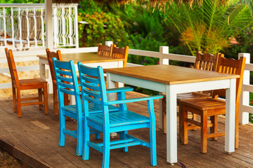 A spacious wooden deck that features tables and chairs arranged on it