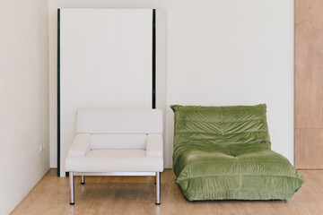 A modern living space featuring sleek white chair and cozy green lounge chair, perfect for relaxation and comfort. minimalist design enhances rooms aesthetic appeal