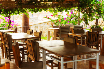 A spacious wooden deck that features tables and chairs arranged on it