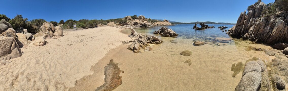 panorama shot of an empty sandy beach, a few rocks at the edge of the picture at Sentier Littoral des Bruzzi, crosica, france