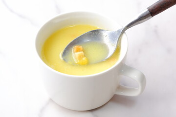 熱々のコーンクリームスープをスプーンでかきまぜる
