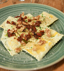 Plato de raviolis rellenos de setas y parmesano, con salsa de tomate seco