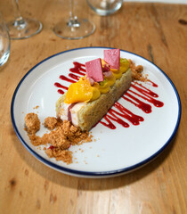 Un trozo de pastel con fruta en un plato blanco en un restaurante.