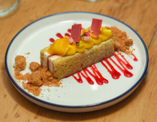 Un trozo de pastel con fruta en un plato blanco en un restaurante.