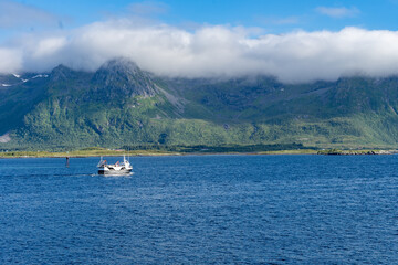 Landscape of small ship in Gimsøystraumen strait in the Lofoten islands, Norway