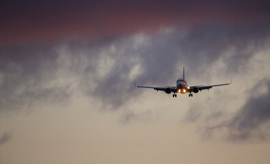 Passengers commercial airplane flying above clouds in sunset light. Concept of fast travel, holidays and business.