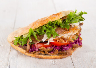 Doner Kebab Doner Kebap fast food snack in flatbread on a wooden table