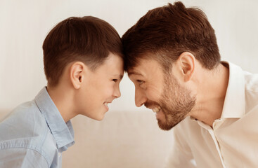 Weekend With Dad. Happy Father And Son Bowing Heads Touching Foreheads Playing Over White Background.