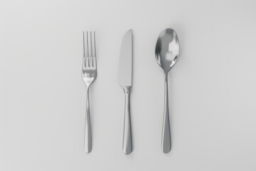 A set of utensils including a knife, fork, and spoon placed on a table